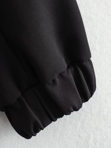 Detailed macro view of elasticated cuffs on a black Y2K loose bomber jacket