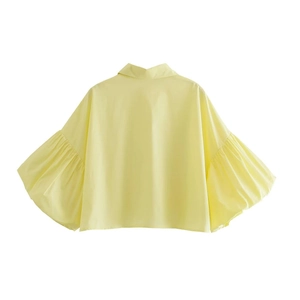 Rear view of yellow puff sleeve shirt showing textured fabric and pleated cuffs
