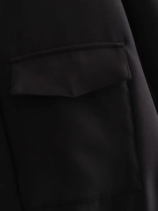 Detailed view of the flap pocket and clean stitching on a black bomber jacket