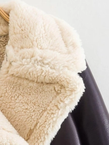 Detail of faux shearling collar and dark brown leather texture on a winter jacket