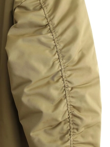 Macro detail of khaki flight jacket sleeve featuring ruching and fine twill fabric