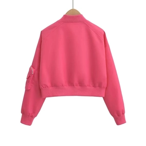 Detail of light pink bomber jacket featuring ribbed collar and sleeve zipper pocket
