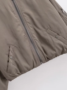 Detalle de chaqueta bomber taupe con cremallera metálica y bolsillo funcional en la manga