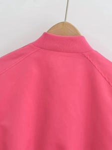 Detailed shot of the ribbed collar and hot pink fabric on a Y2K style bomber jacket