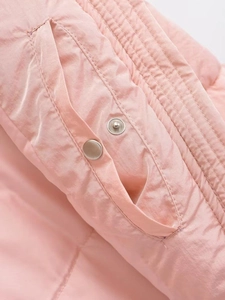 Detailed macro view of a pink padded vest pocket with silver snap button and stitching