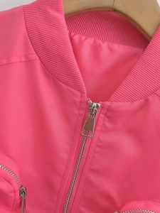 Detail of pink bomber jacket showing silver metal zipper and ribbed knit collar texture