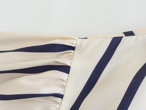 Close-up detail of satin texture with navy blue diagonal stripes and fine stitching