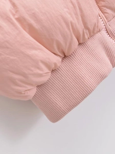 Detail shot of the pink puffer vest featuring ribbed knit cuffs and a matching zipper closure