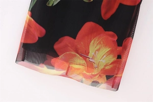 Detail of floral mesh dress showing sheer fabric with orange flower print and hem stitching