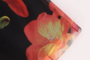 Macro view of sheer mesh fabric with vintage orange floral patterns on black mesh