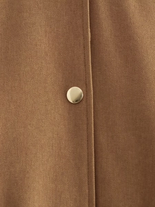 Macro shot of twill fabric texture and golden metal snap button on brown bomber jacket