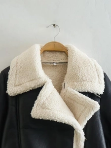 Detail of S-size tag on contrast faux leather jacket with plush white fleece lapel