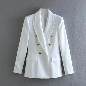 Detailed view of white double-breasted blazer featuring luxury decorative gold buttons