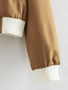 Detail of brown canvas bomber jacket featuring white elastic ribbed cuffs and hem trim