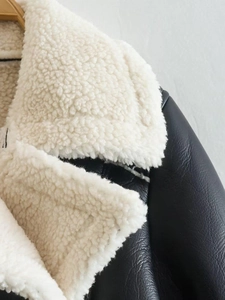 Close-up of the plush white fleece collar and black faux leather texture on the jacket
