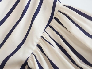 Detailed view of diagonal blue and white stripes with fine pleats on lightweight fabric