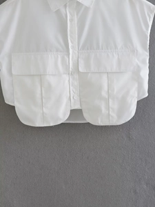 Detail of white cropped sleeveless shirt with lapel collar and large flap chest pockets