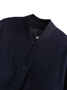 Detail of navy blue bomber jacket showing ribbed stand collar and round snap button
