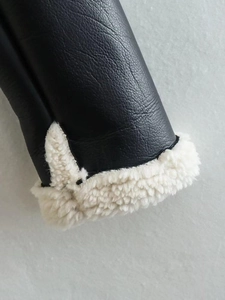 Detailed close-up of jacket cuff with black pebbled leather and white fleece lining