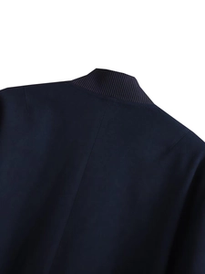 Detail of navy blue bomber jacket featuring a ribbed knit stand collar and vertical back seam