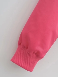 Detailed close-up of pink bomber jacket ribbed cuffs and high-quality fabric texture