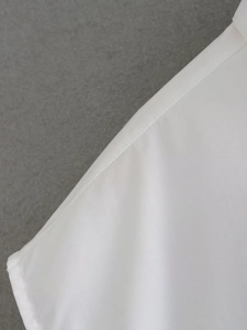 Detail view of high-quality stitching on white cotton fabric for summer Y2K crop shirts