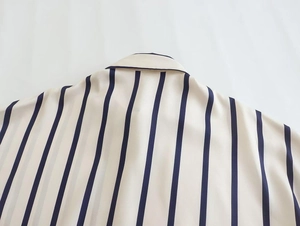 Detailed view of striped shirt collar with beige fabric and dark blue vertical stripes