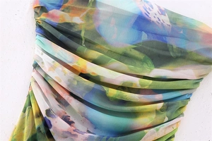 Detailed macro view of vibrant abstract floral print mesh dress with ruched texture