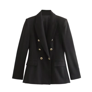 Close-up of golden embossed buttons and symmetrical flap pockets on black blazer