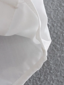 Detail of flat seam stitching and neat edging on a white Y2K style cropped shirt