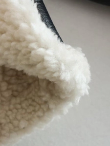 Detail of premium black lychee leather jacket with thick white sherpa fleece lining
