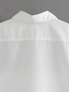 Close-up of the classic lapel collar and shoulder stitching on a white short sleeve shirt