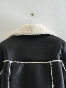 Detail of the back stitching and white faux fur trim on the black shearling biker jacket