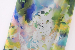 Detailed macro view of colorful floral print fabric with vibrant watercolor gradient effects