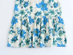 Dettaglio dell'orlo di un abito midi floreale con fiori blu e balze a strati eleganti
