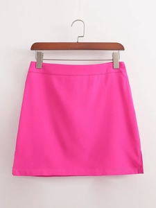 Détail d'une mini-jupe Y2K magenta avec fente latérale sur un cintre en bois