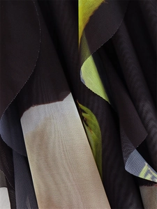 Macro detail of breathable Y2K mesh fabric with yellow and green abstract prints