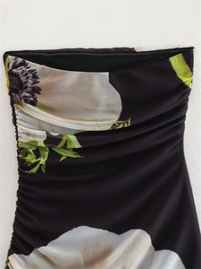 Detail of floral mesh dress featuring side ruching and elegant anemone print on black fabric