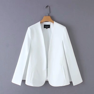 Detailed close-up of white collarless blazer cape with side slit sleeves on a wooden hanger