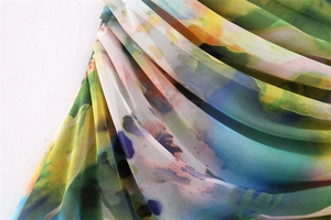 Close-up of Y2K style mesh fabric with vibrant floral prints and pleated detail