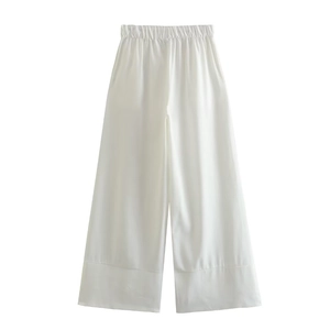 Détail d'un pantalon blanc large en lin avec taille élastique et ourlets plissés