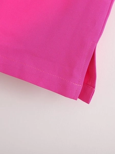 Détail de la jupe rose vif avec fente latérale et coutures plates de précision