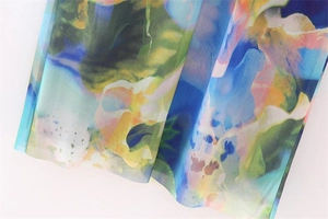 Macro detail of sheer mesh fabric featuring abstract watercolor floral print in vibrant colors