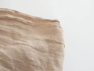 Gros plan détaillé sur la texture en lin beige naturel et les coutures de précision du vêtement