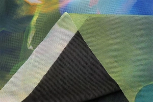Macro detail of breathable mesh fabric with vibrant green and blue abstract floral print