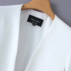 White Y2K cape blazer jacket with split sleeve design and notched lapels shown on a wooden hanger