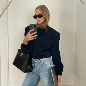 Navy wool bomber jacket with structured shoulders and ribbed cuffs in minimalist style