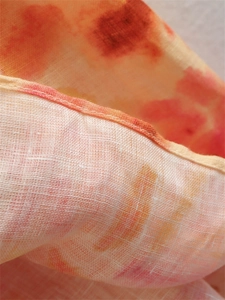 Vista macro del tessuto dell'abito midi Y2K con stampa tie-dye arancione e cuciture dell'orlo