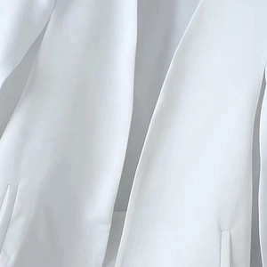 White sleeveless cape blazer with notched lapels and slit detail in a minimalist Y2K style