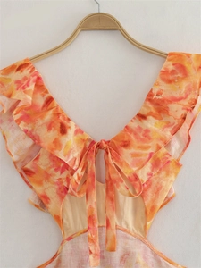Dettaglio dell'abito midi con stampa floreale tropicale, scollo a V e volant con laccetti